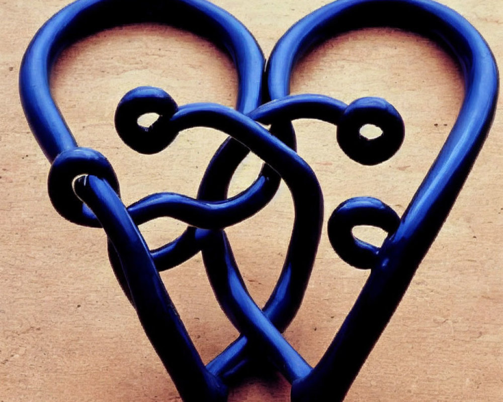 Blue Metal Double Heart-Shaped Sculpture on Beige Background