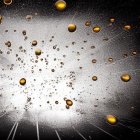 Shimmering golden droplets in suspended motion with bokeh background