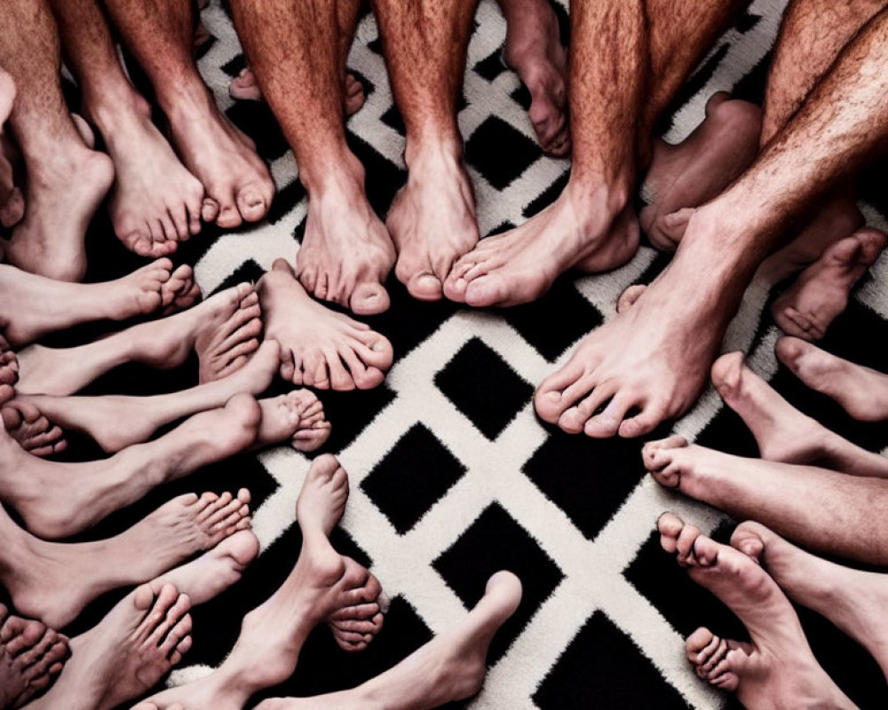 Barefoot people in circle over geometric carpet with focus on feet