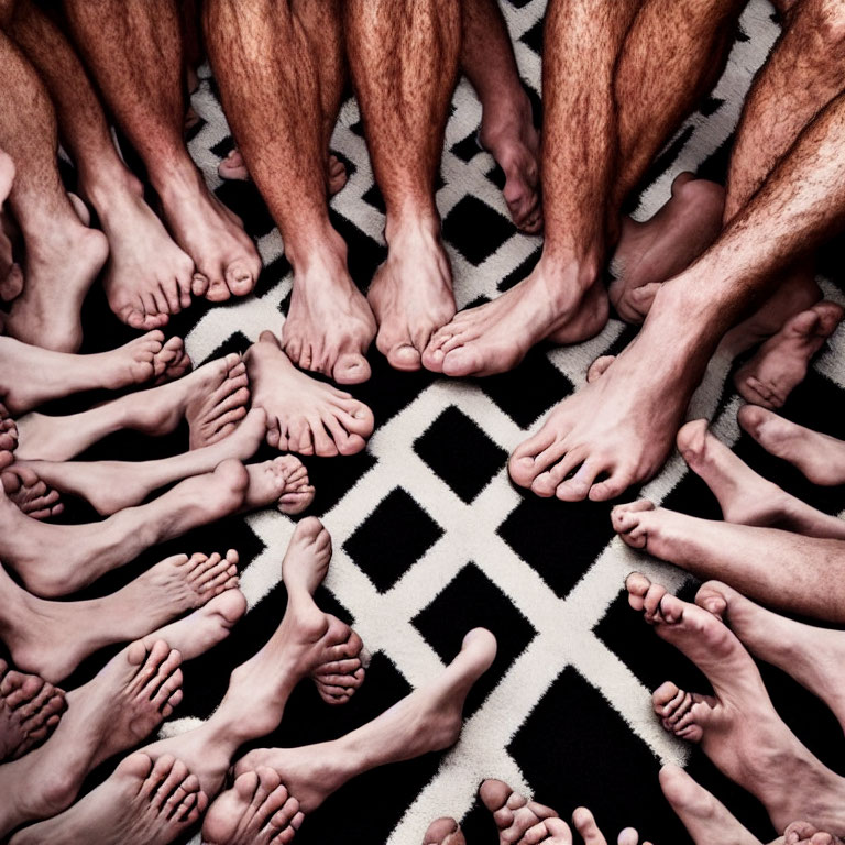 Barefoot people in circle over geometric carpet with focus on feet