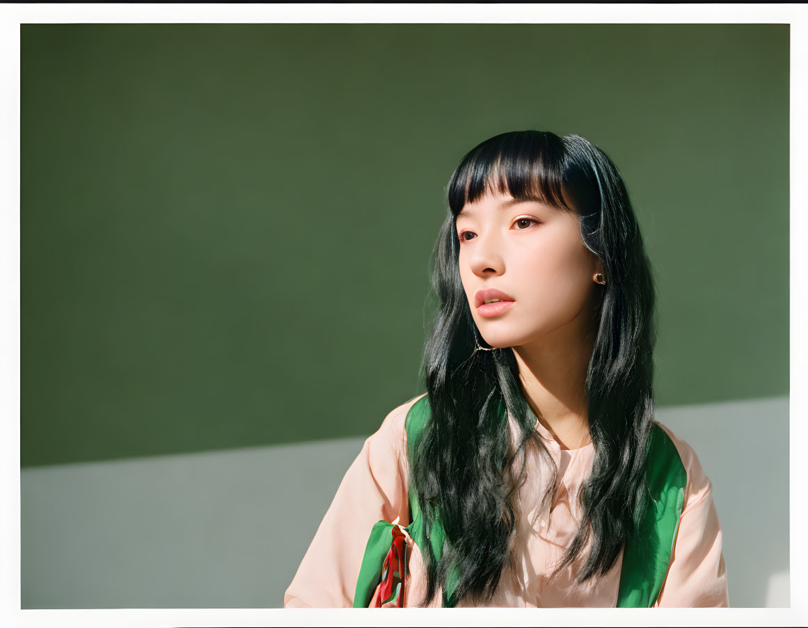 Black-Haired Woman in Pastel Blouse on Green Background