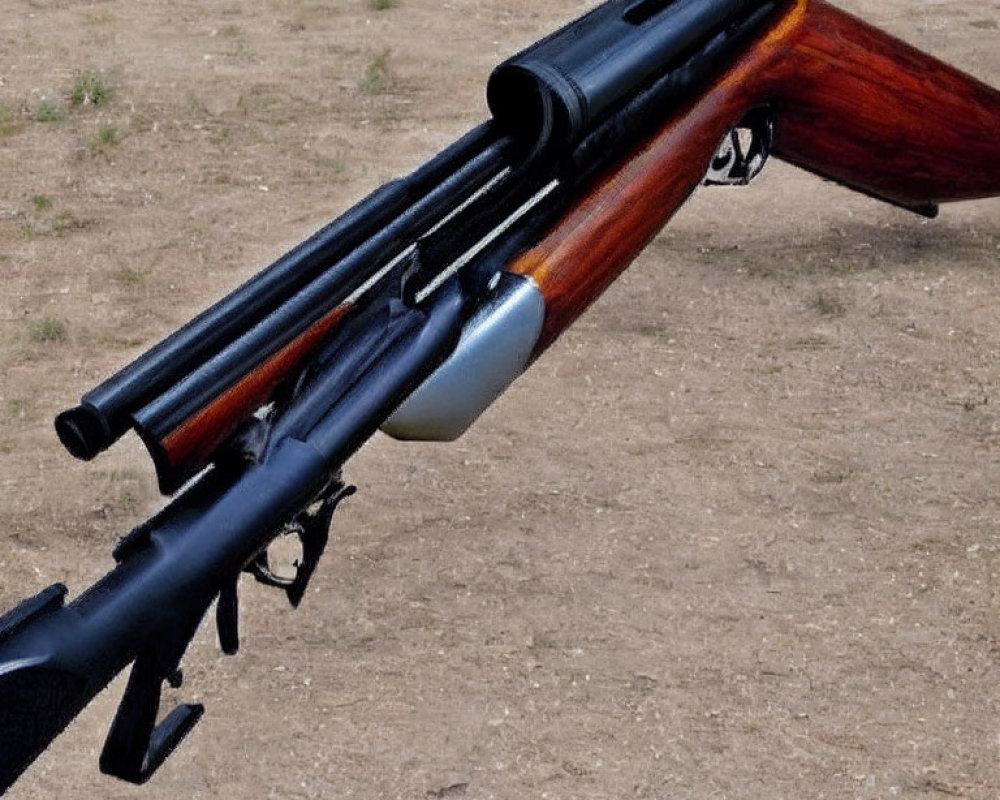 Close-up shotguns with wooden stocks on gravel background