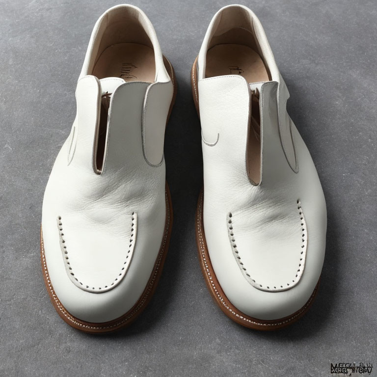 White Slip-On Dress Shoes with Brogue Detailing on Gray Background