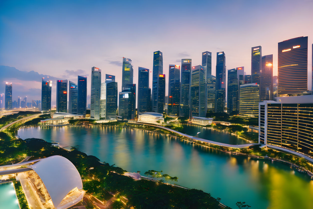 Modern city skyline at dusk with illuminated skyscrapers reflecting on calm river amid lush greenery