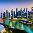 Modern city skyline at dusk with illuminated skyscrapers reflecting on calm river amid lush greenery