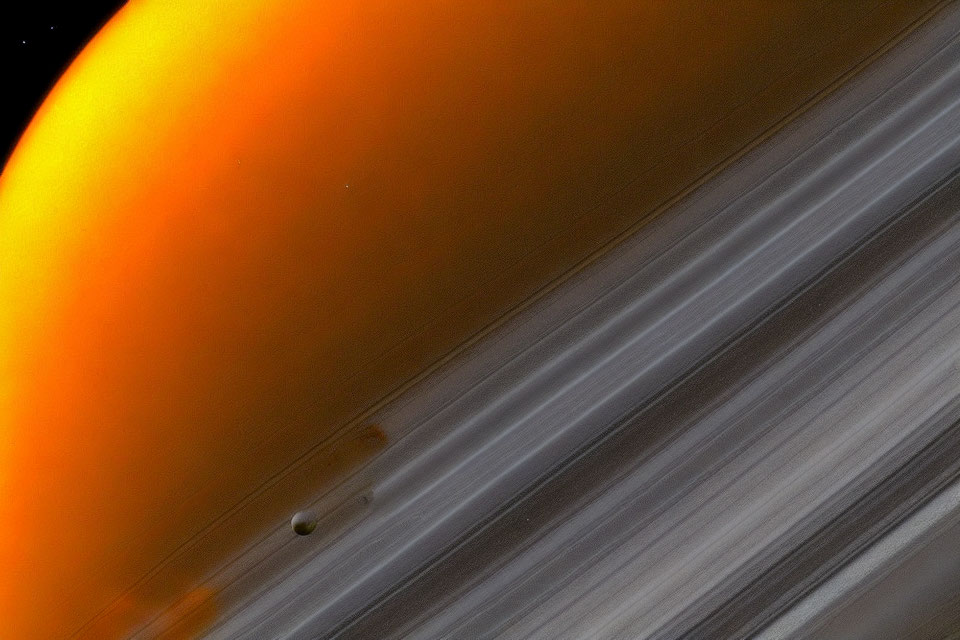 Saturn's orange-hued atmosphere with iconic rings and moon in space.