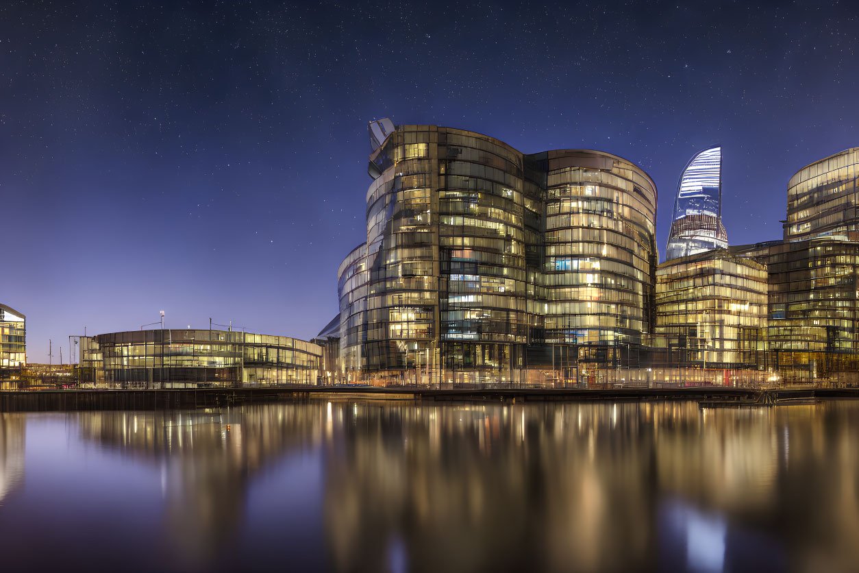 Panoramic Night View of Modern Glass Buildings Reflected in Water