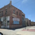 Abandoned two-story desert building with graffiti and boarded-up windows