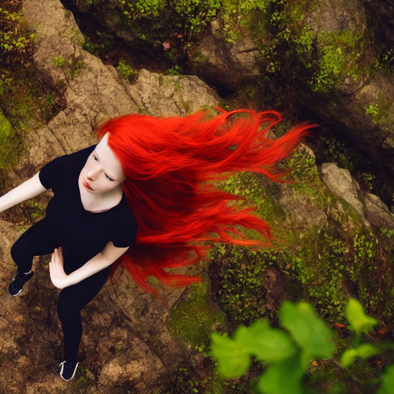 Person with Bright Red Hair in Black Outfit on Rocky Forest Floor