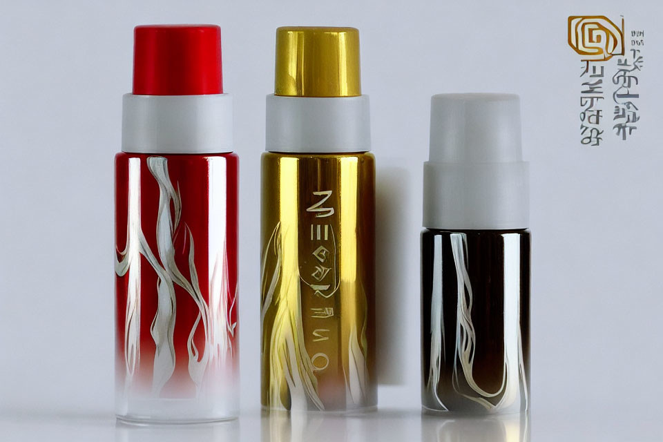 Three Elegant Red, Gold, and Black Spray Bottles on White Background