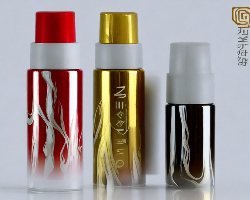 Three Elegant Red, Gold, and Black Spray Bottles on White Background