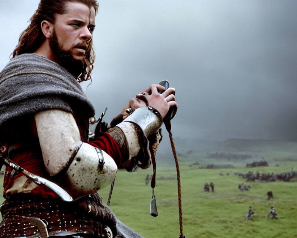 Medieval knight in armor with fur cloak on cloudy day, battle scene in background