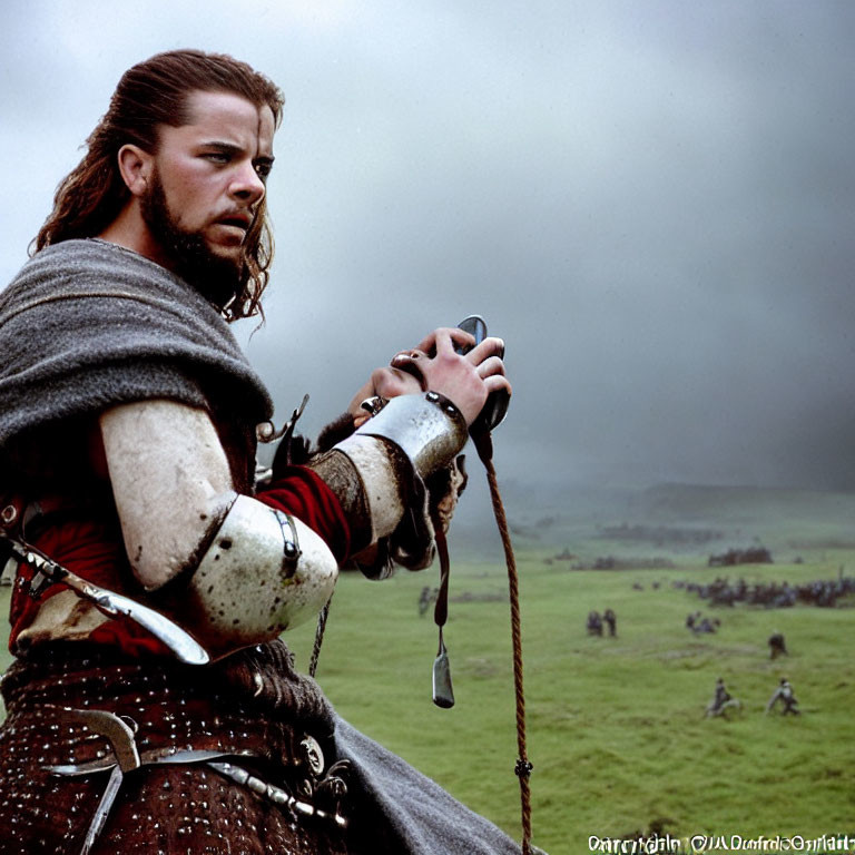 Medieval knight in armor with fur cloak on cloudy day, battle scene in background