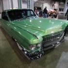 Vintage Green Cadillac Displayed Among Classic Cars in Showroom