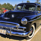 Stylized classic car with shiny blue finish and white-wall tires parked outdoors