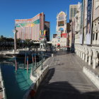 Snow-covered buildings and lampposts by a calm river in serene winter setting