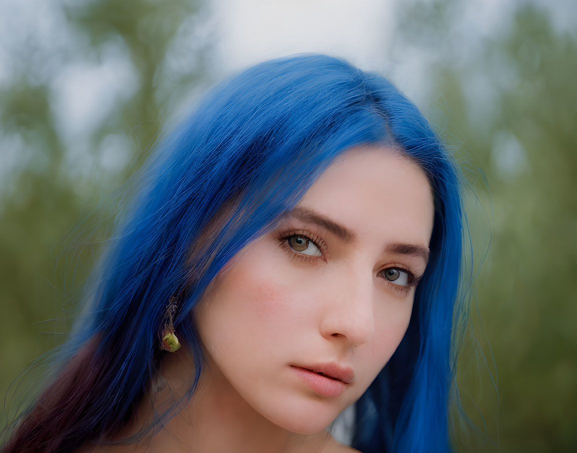 Close-Up Portrait of Person with Striking Blue Hair and Intense Gaze