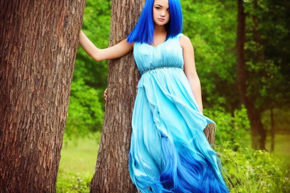 Woman with Bright Blue Hair in Matching Dress Standing in Lush Green Forest