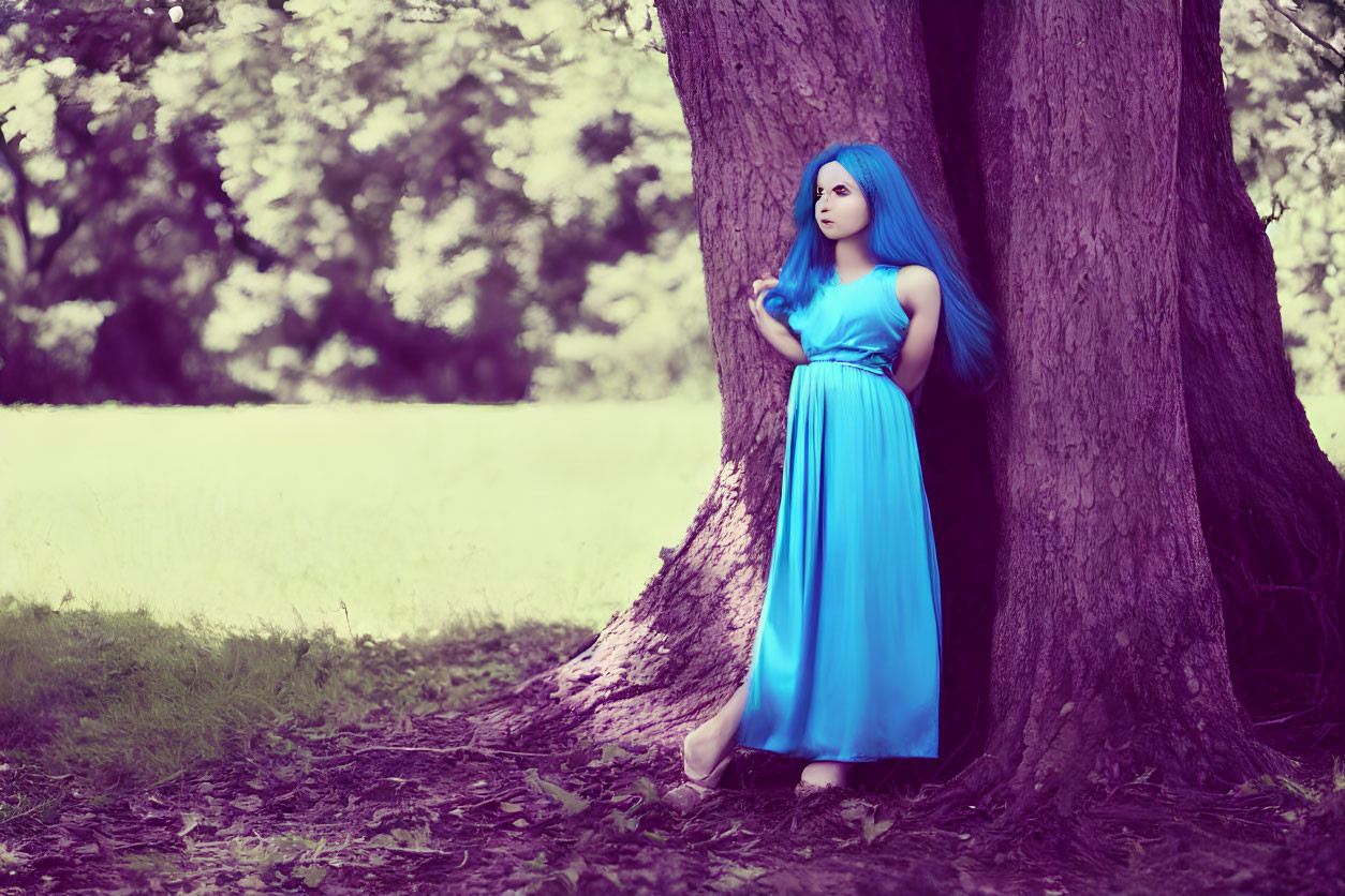 Blue-haired woman in matching dress gazes into the distance by tree in woodland