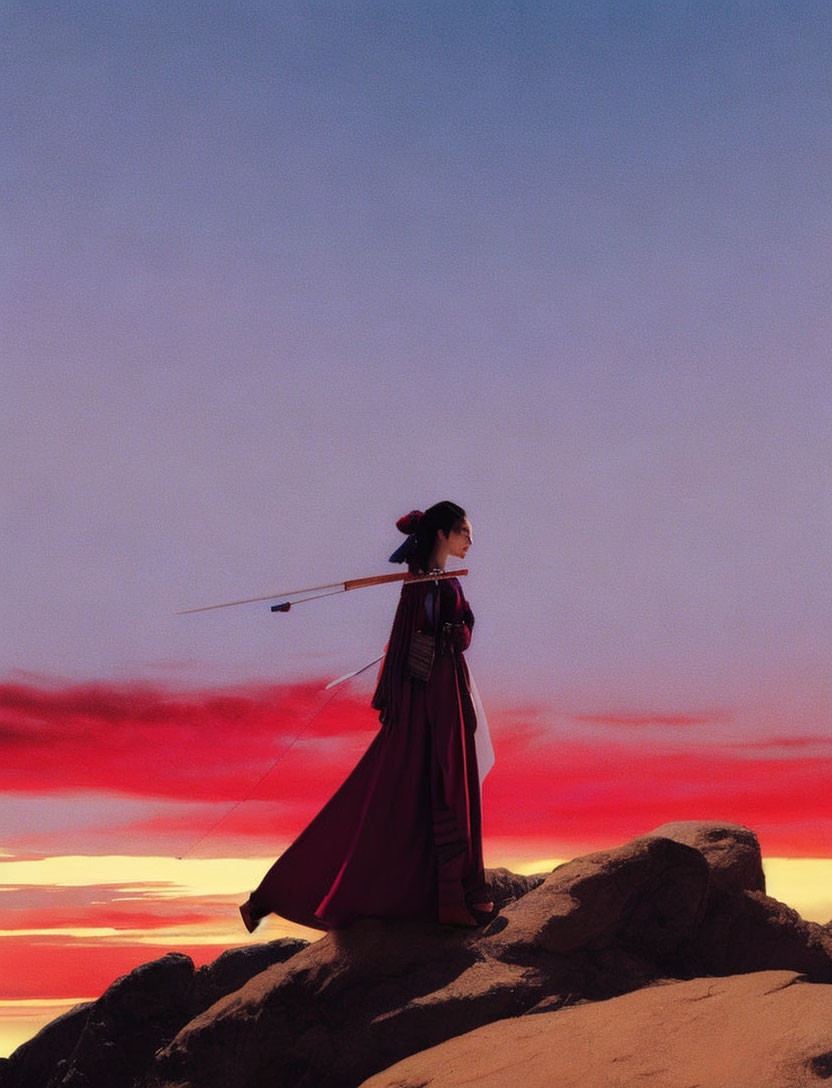 Person in Traditional Attire with Sword Gazes at Sunset Sky