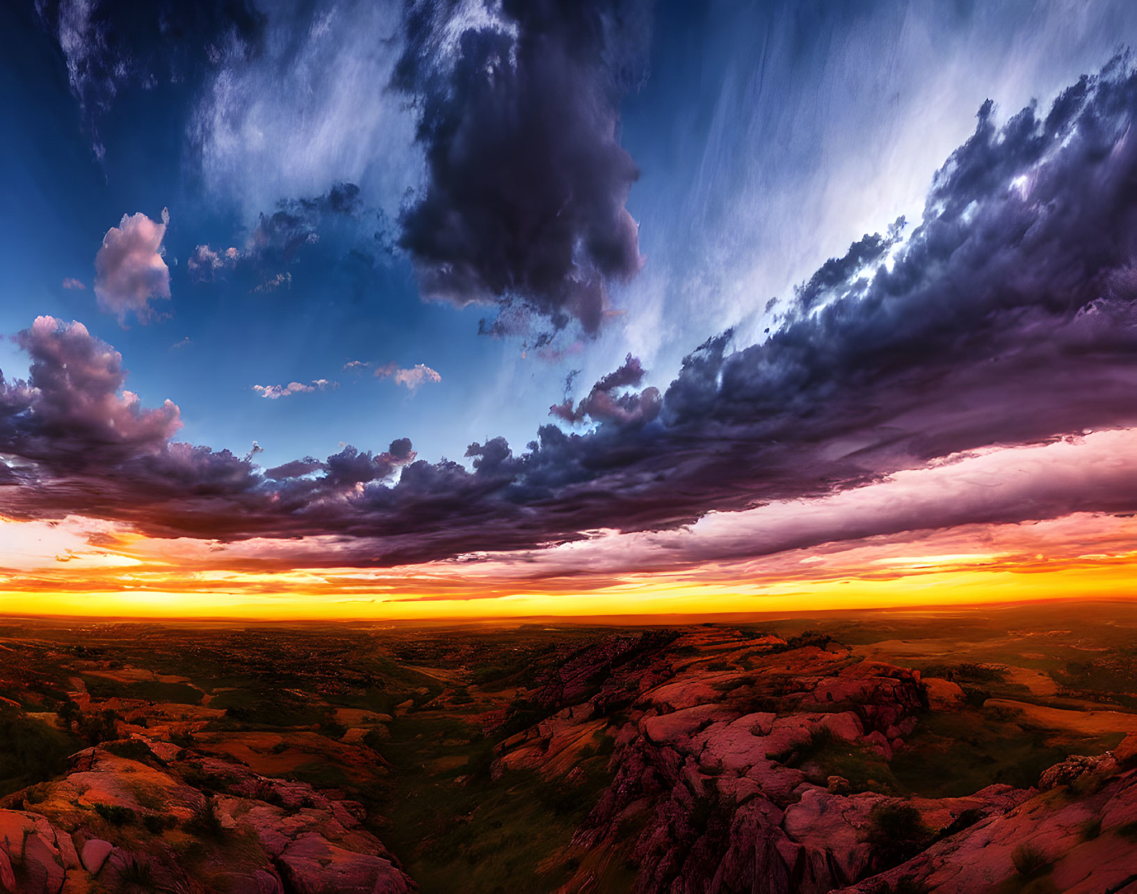 Dramatic sunset over rocky landscape with warm and cool tones