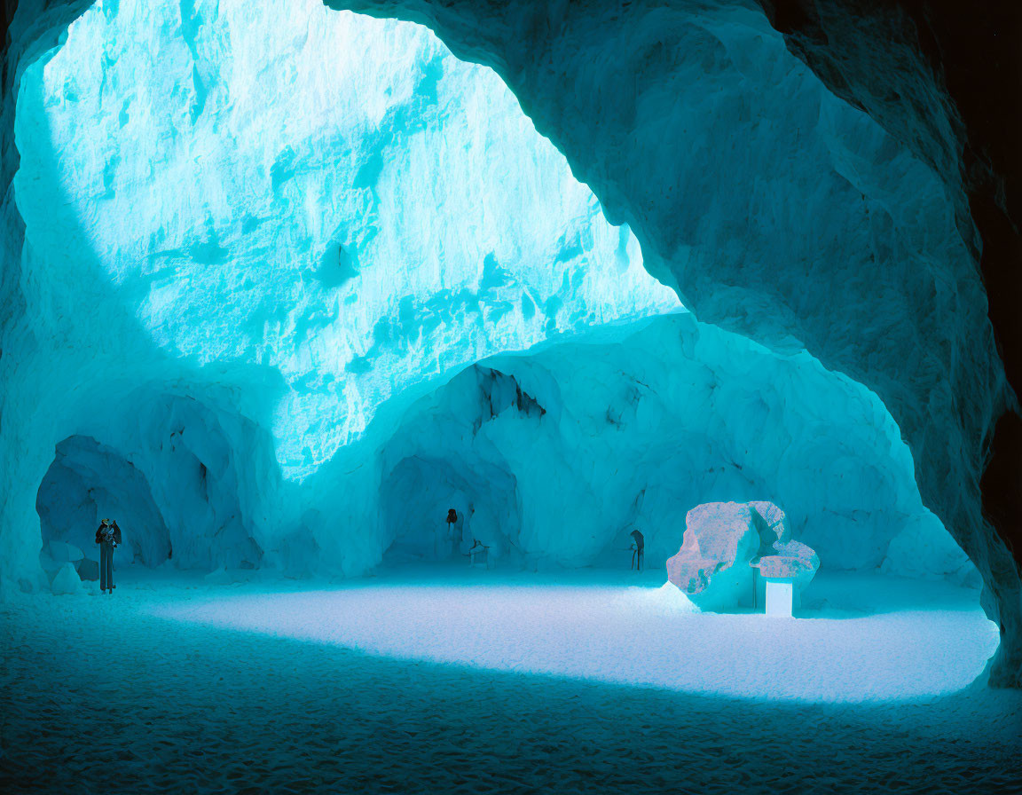 Explorers in mystical icy blue cave with sunlight filtering through