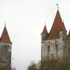 Stone castle with spires in lush gardens under a twilight sky