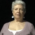 Portrait of Woman with Blue Hair in Pearl Jewelry and White Fur Against Dark Background