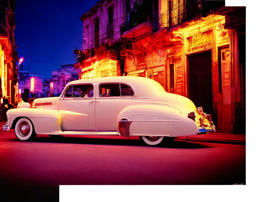 Vintage white car parked on vibrant twilight street with warm illuminated buildings