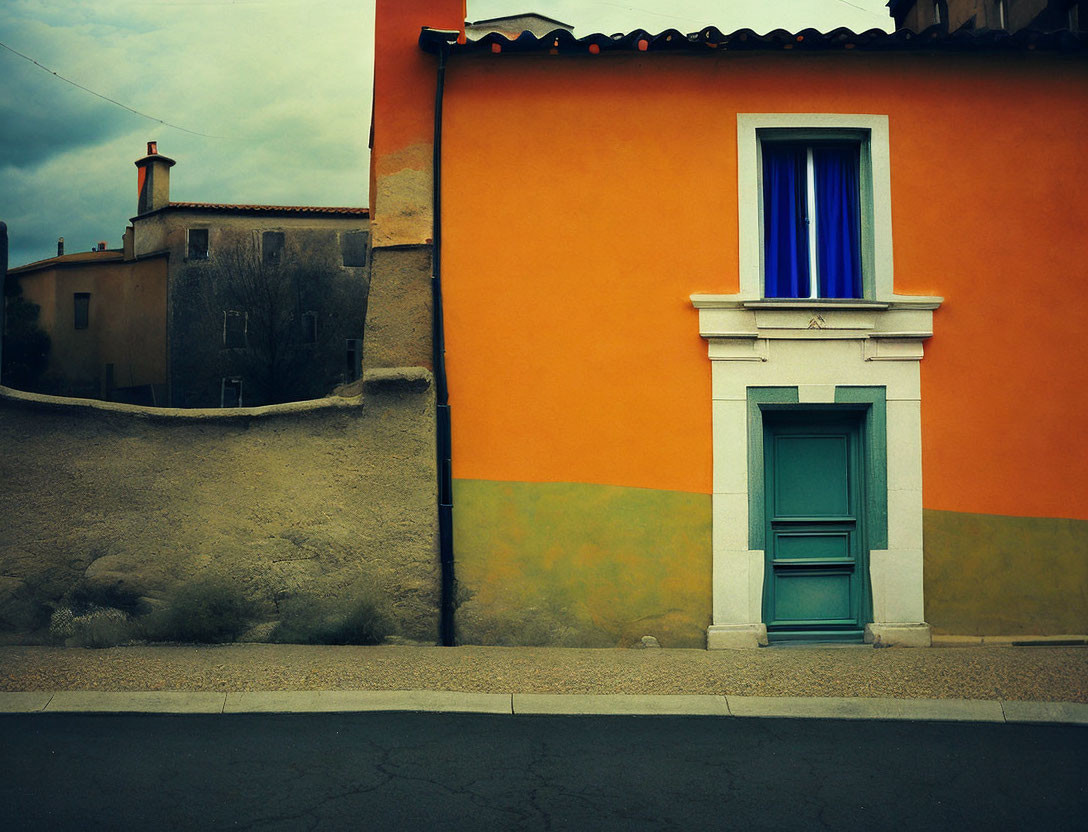 Vibrant orange, blue, and green house against grey background