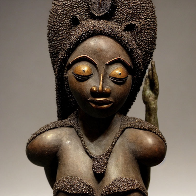 Intricately carved African wooden statue of female figure with elaborate hairstyles and textured surface