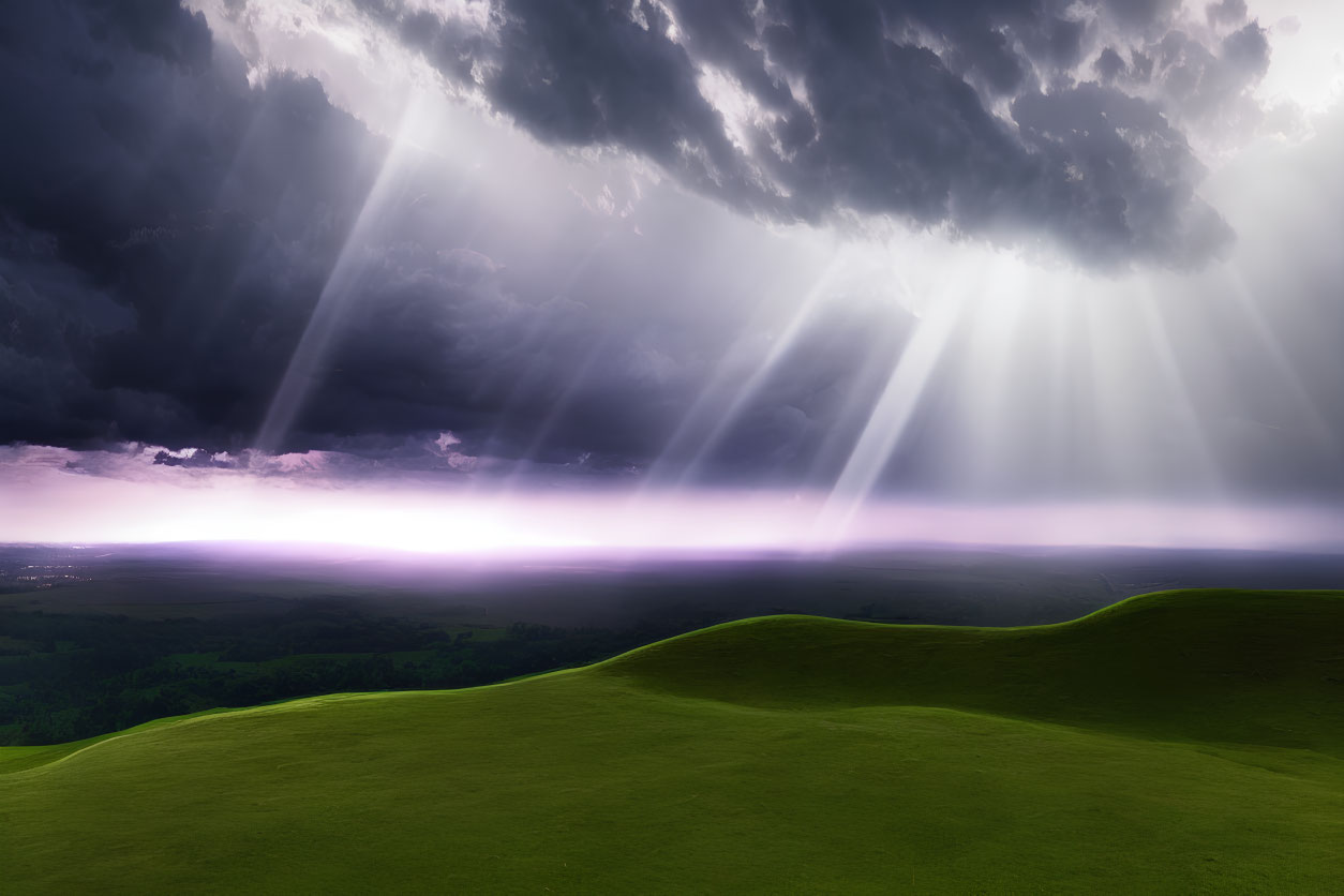 Sunbeams through dark clouds on lush green landscape