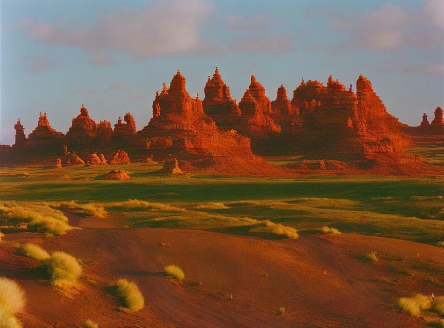 Majestic red sandstone towers against blue sky with green vegetation