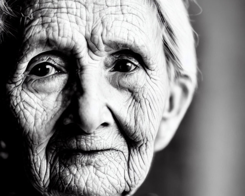 Elderly woman portrait in black and white with deep wrinkles and expressive eyes