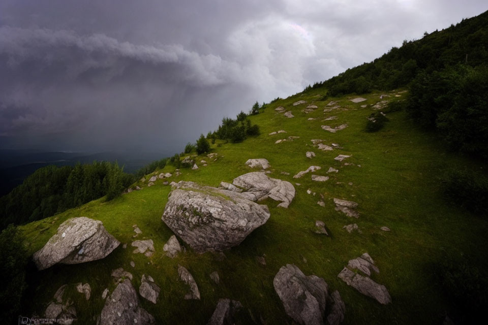 Stormy Sky with Faint Rainbow Over Mountain Slope