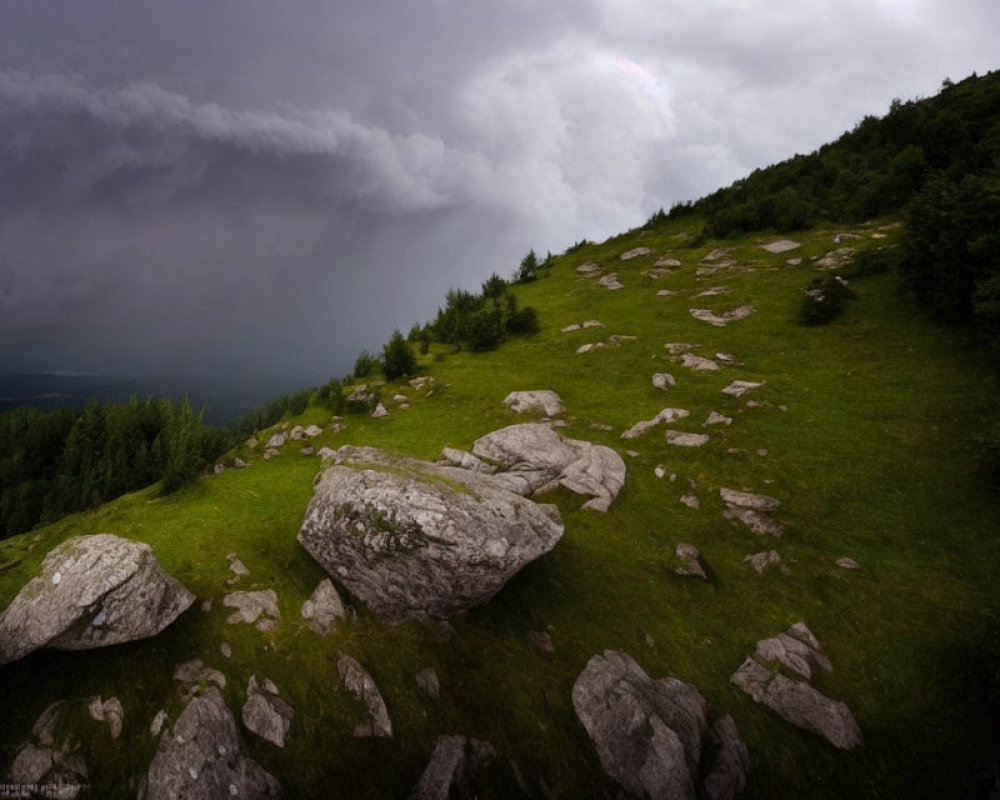 Stormy Sky with Faint Rainbow Over Mountain Slope