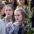 Group of individuals in nature-themed costumes with floral headpieces, gathering closely.