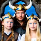 Three Viking individuals in horned helmets with blue eyes and blonde hair in a forest setting.