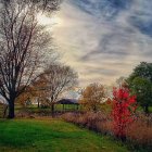 Tranquil lake with autumn trees reflecting under dramatic sunset sky