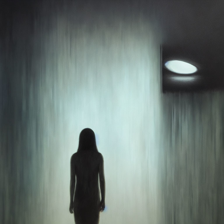 Silhouette of person in heavy rain under streetlight
