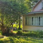 Victorian house with lush garden and blooming flowers in soft sunlight