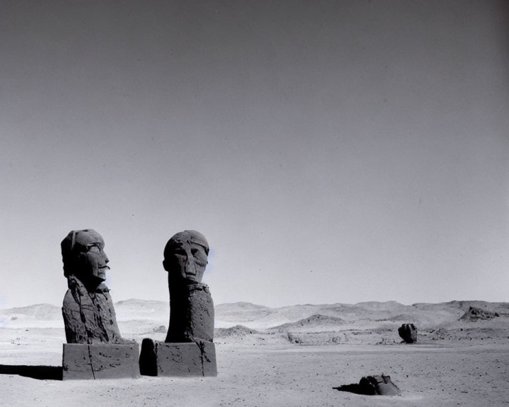 Ancient stone statues of pharaoh-like figures in desert landscape