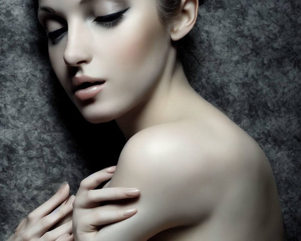 Serene expression with prominent makeup against textured backdrop