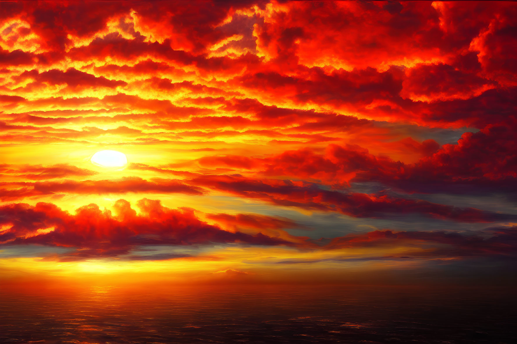 Vibrant sunset with deep red and orange clouds casting fiery glow