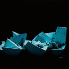 Deteriorating blue rowboats abandoned in dark setting