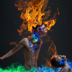 Person with fiery wolf head and vibrant flames on dark background