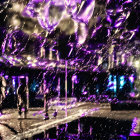 Colorful night lights reflecting on people walking through water splash, creating dynamic effect