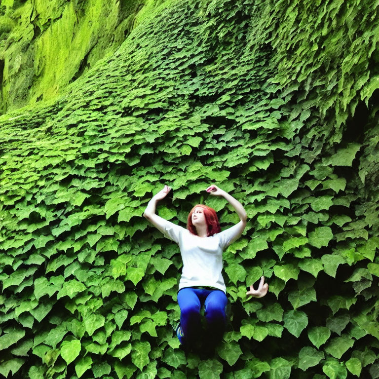 Person forming heart shape on lush green slope