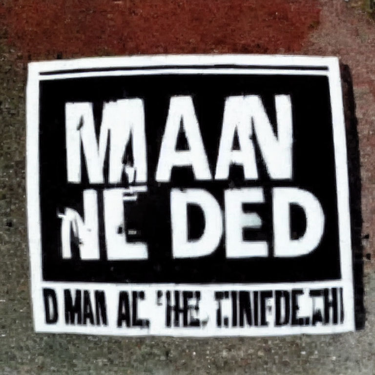 Monochrome ground sticker with bold, partially obscured text.