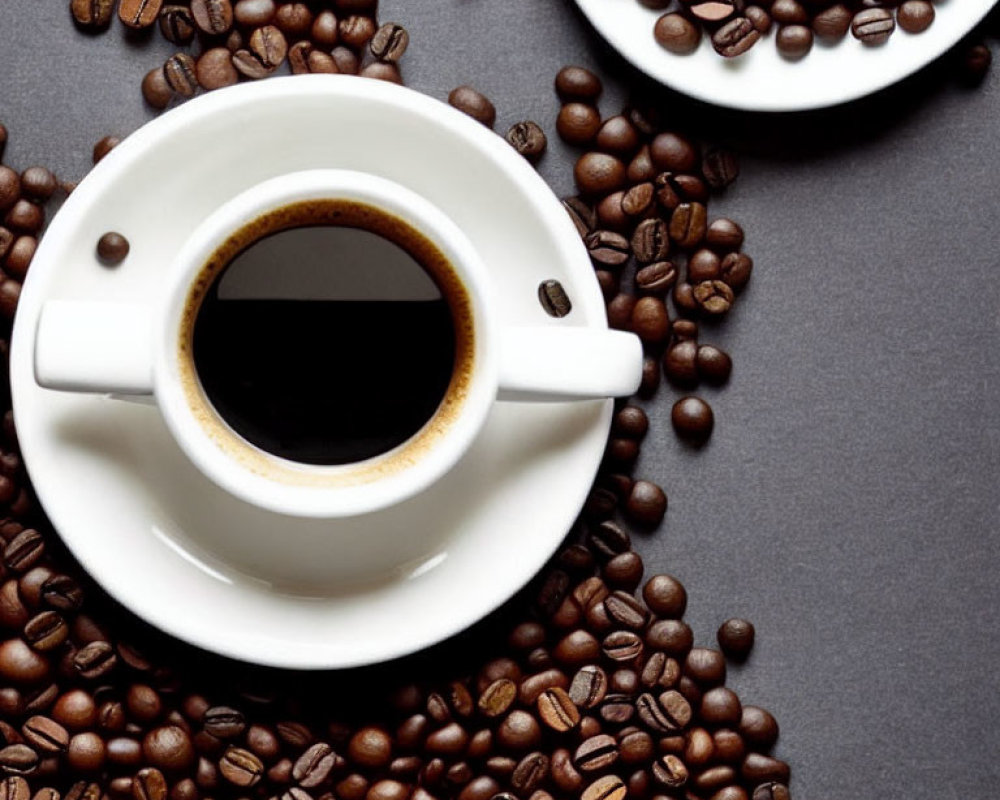 Coffee Cup with Saucer on Grey Surface and Scattered Beans